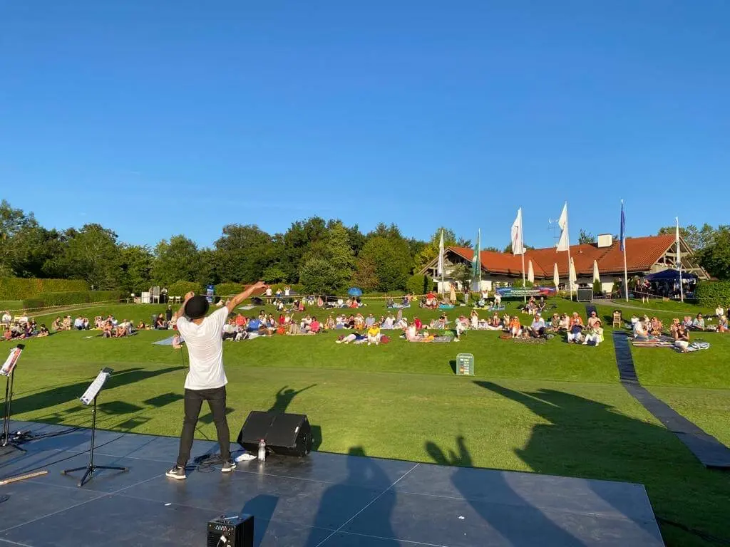 Beatboxer auf einer Bühne vor einem Publikum auf einer Rasenfläche
