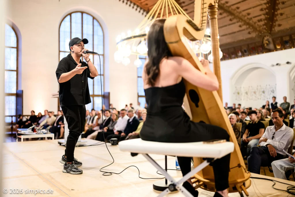 Beatboxer mit Mikrofon neben einer Harfenistin